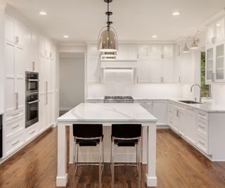 White kitchen with narrower shaker style cabinets and matching kitchen island
