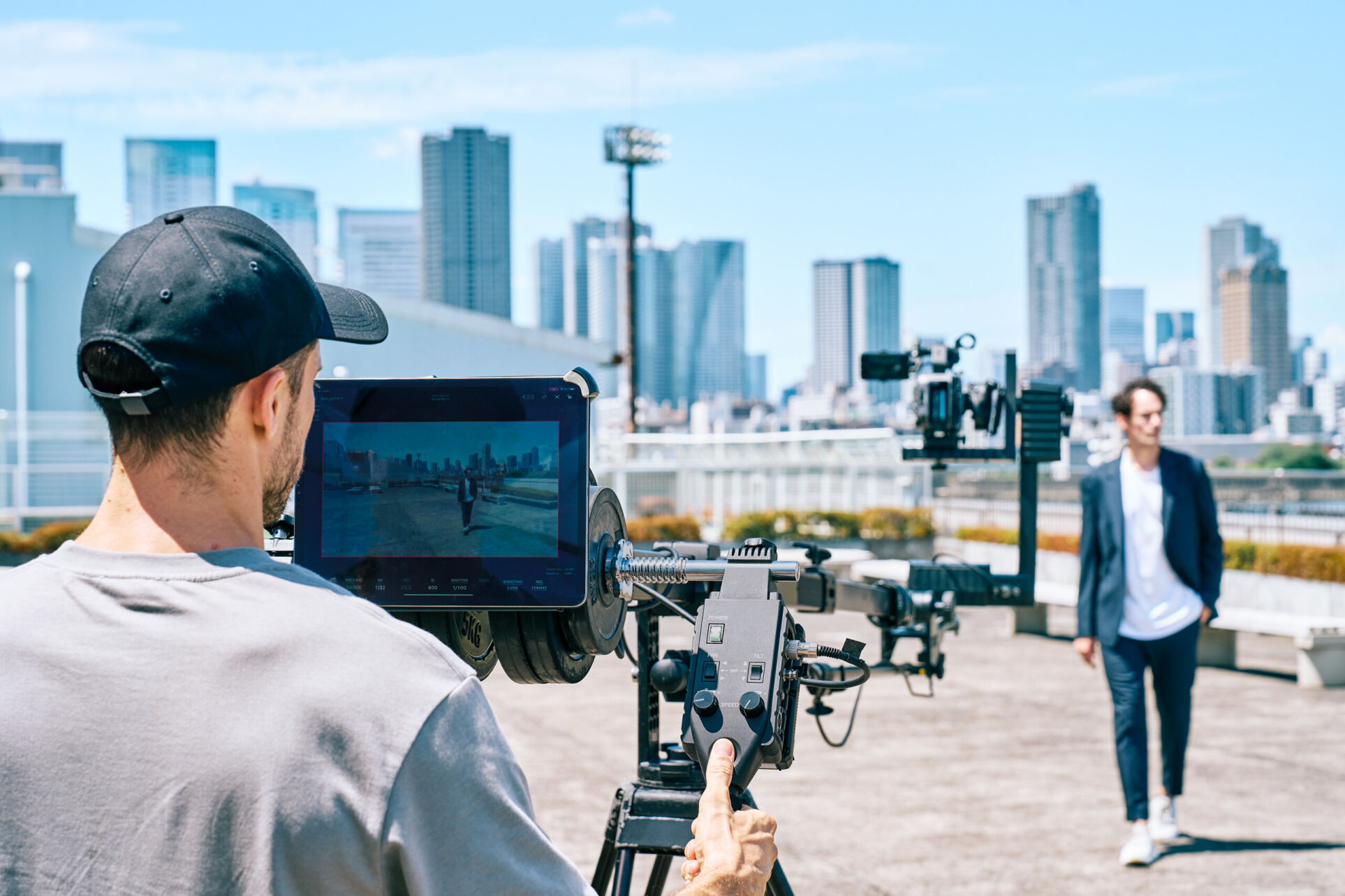 tablet displaying the frame via Monitor & Control app with camera in the distance on the end of a jib crane