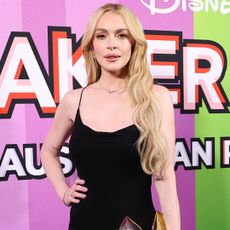 Lindsay Lohan attended a Freakier Friday premiere in Australia wearing a Saint Laurent little black dress and a gold fortune cookie clutch