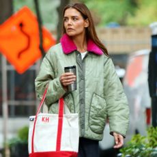 Katie Holmes walking in New York City wearing a quilted coat and a KH tote bag