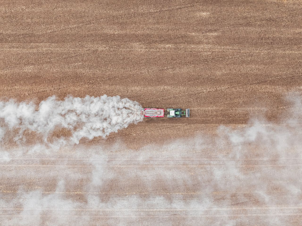 An aerial photograph of a tractor spreading fertilizer.