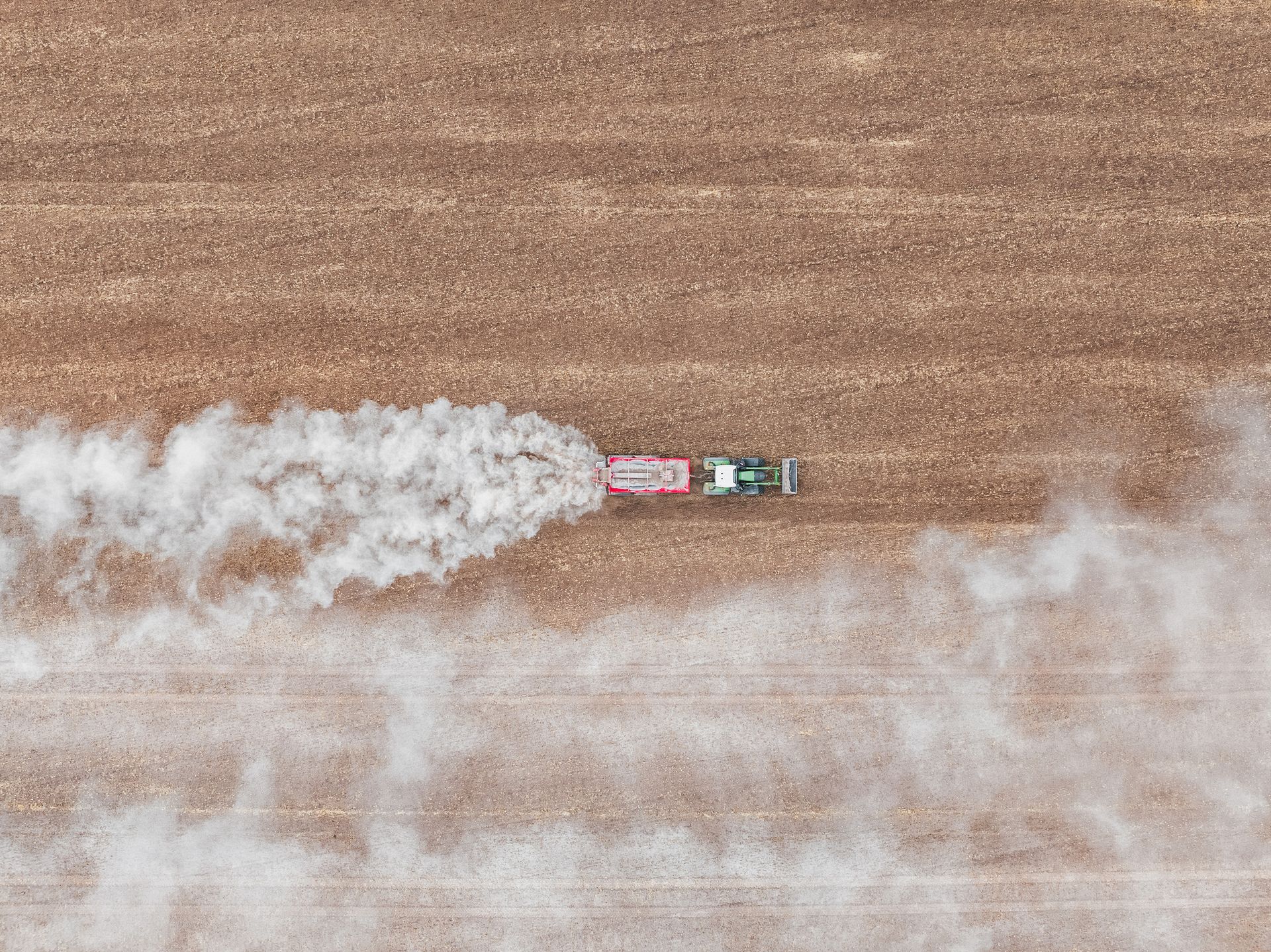 An aerial photograph of a tractor spreading fertilizer.