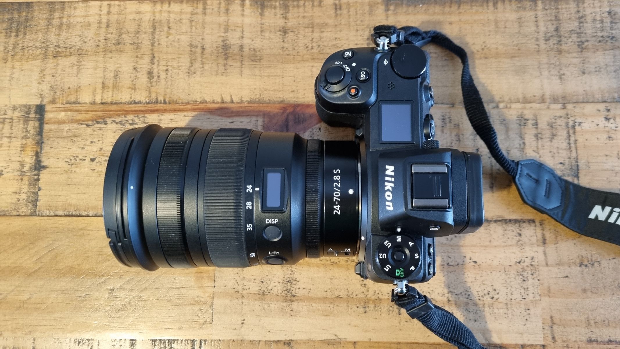 Product image of the lens on a wooden table attached to a Nikon Z6