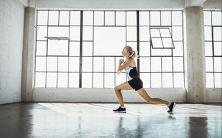 A woman doing lunges in a studio space