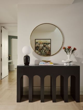 hallway table, mirror about it with artwork reflecting in it