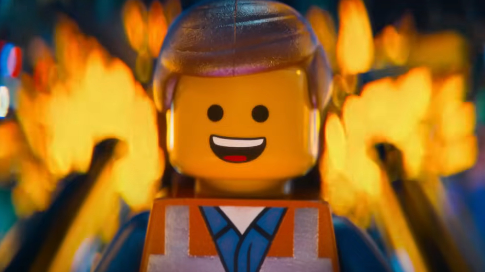 Emmet Brickowski uśmiecha się, stojąc przed ogniem podczas filmu Lego.