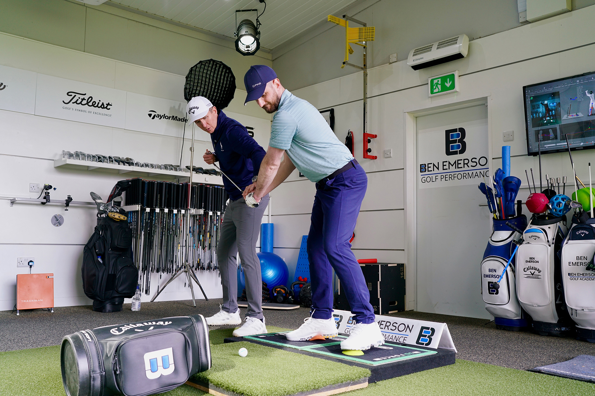 Baz Plummer being coached by Ben Emerson in a tour level golf setting, with Ben demonstrating a part of the sequence that Baz needs to work on
