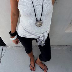 Makenna wears a white tank, capri pants, and flip-flops.