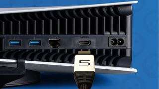 An HDMI cable hovering over the PS5's HDMI port