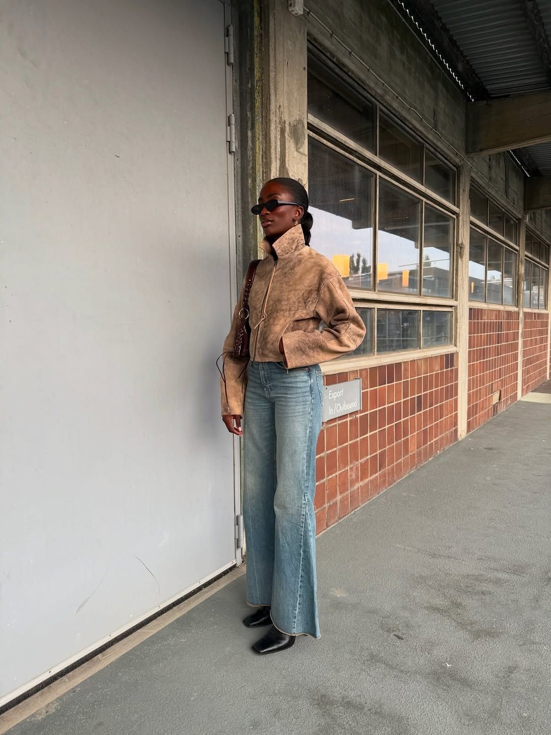Woman wearing dirty denim jeans, a fall 2025 trend.