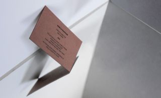 Fashion Week invitation shown on a brown cardboard print.