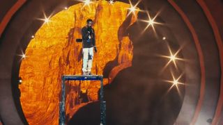 Travis Scott standing above the stage on a platform, performing at Astroworld.