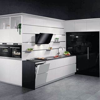 Open door dishwasher in beautiful black and white kitchen together with other appliances