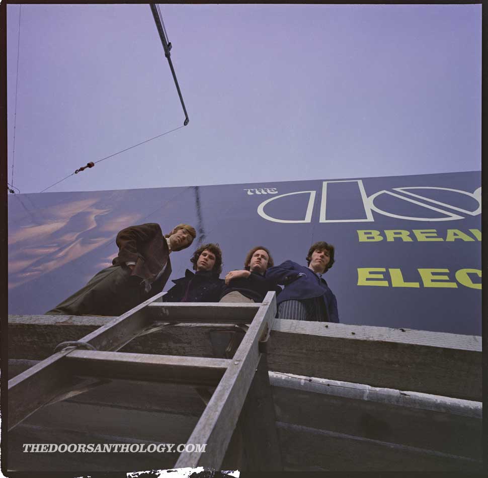 The Doors standing beneath a Doors billboard