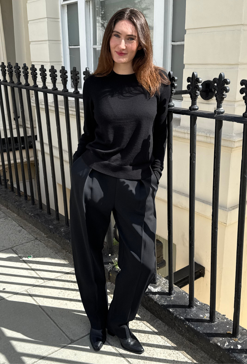 An image of Who What Wear UK news writer Natalie Munro wearing the R&amp;oacute;he Puck Sculptural Tailored Trousers with black boots and a black knt.