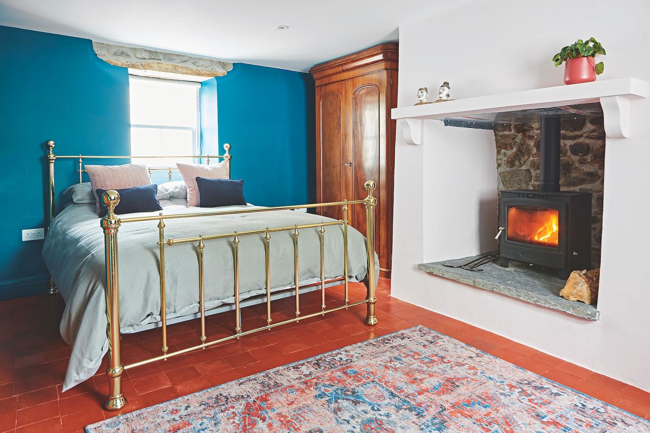 small bedroom with stone fireplace and woodburning stove