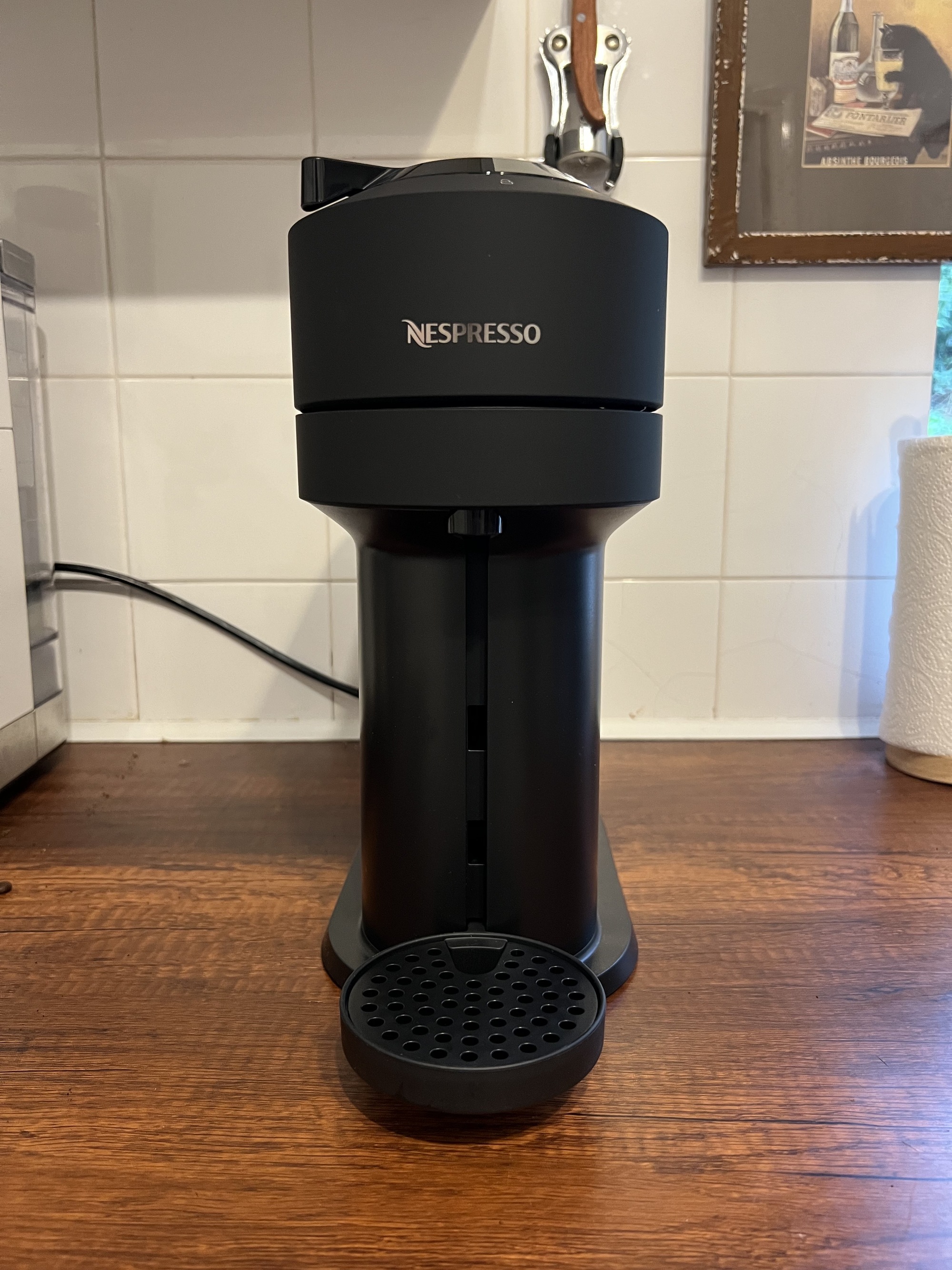 Image of a black Nespresso Vertuo Next machine on a wooden kitchen countertop