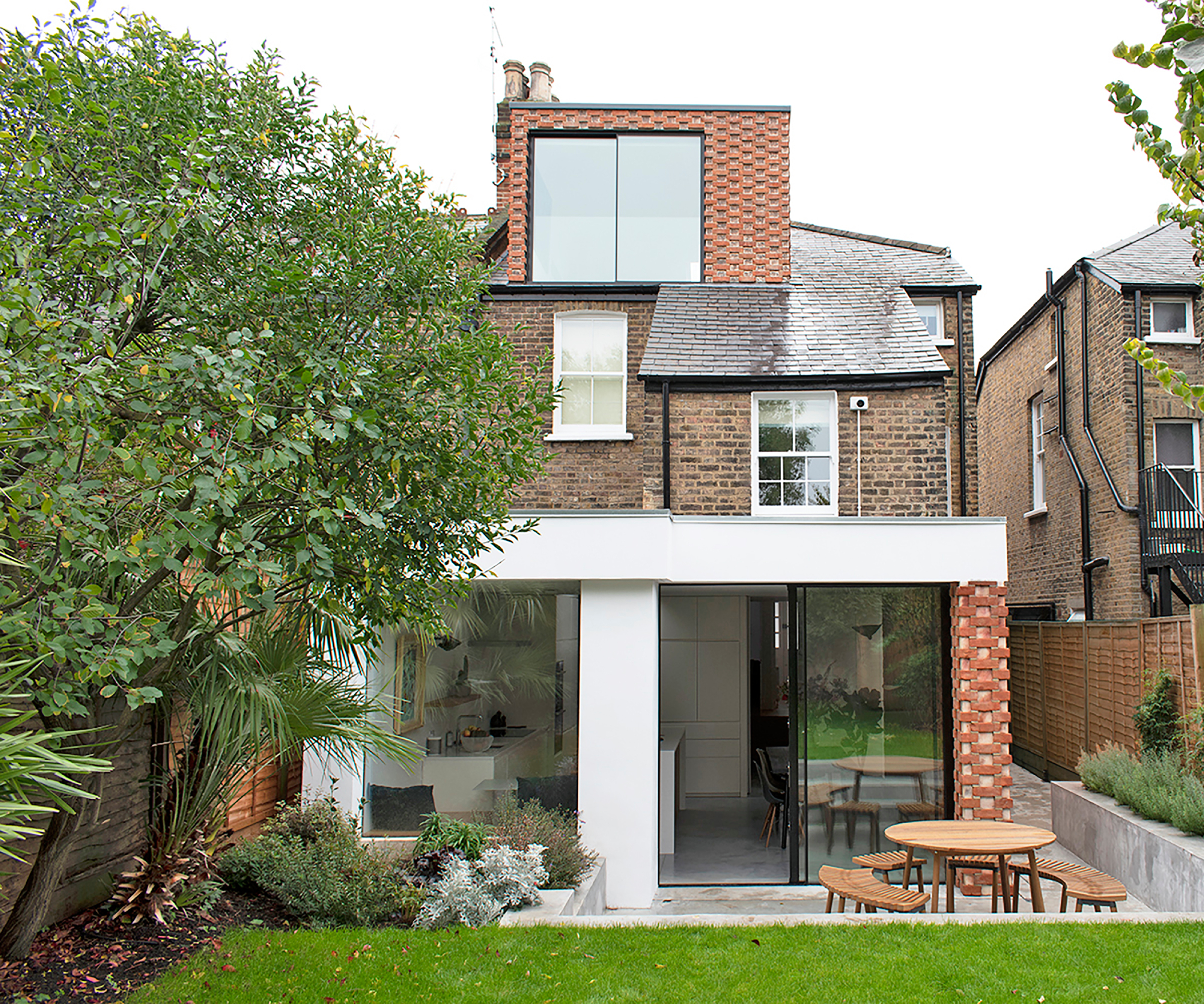 semi detached brick house with brick clad loft conversion and rear extension with white render and same brick cladding on end wall