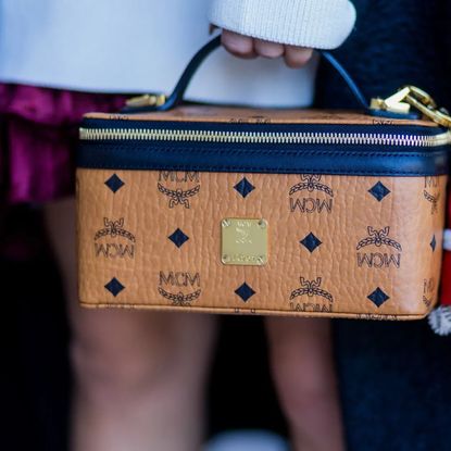 A woman holding an MCM vanity bag