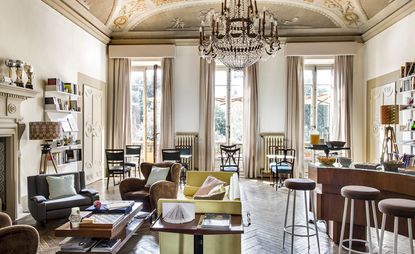 High ceiling dining room featuring parquet flooring, mismatched tables and chairs and a chandelier