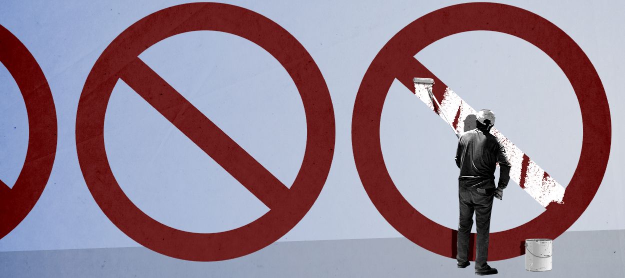 A man painting on a symbol.