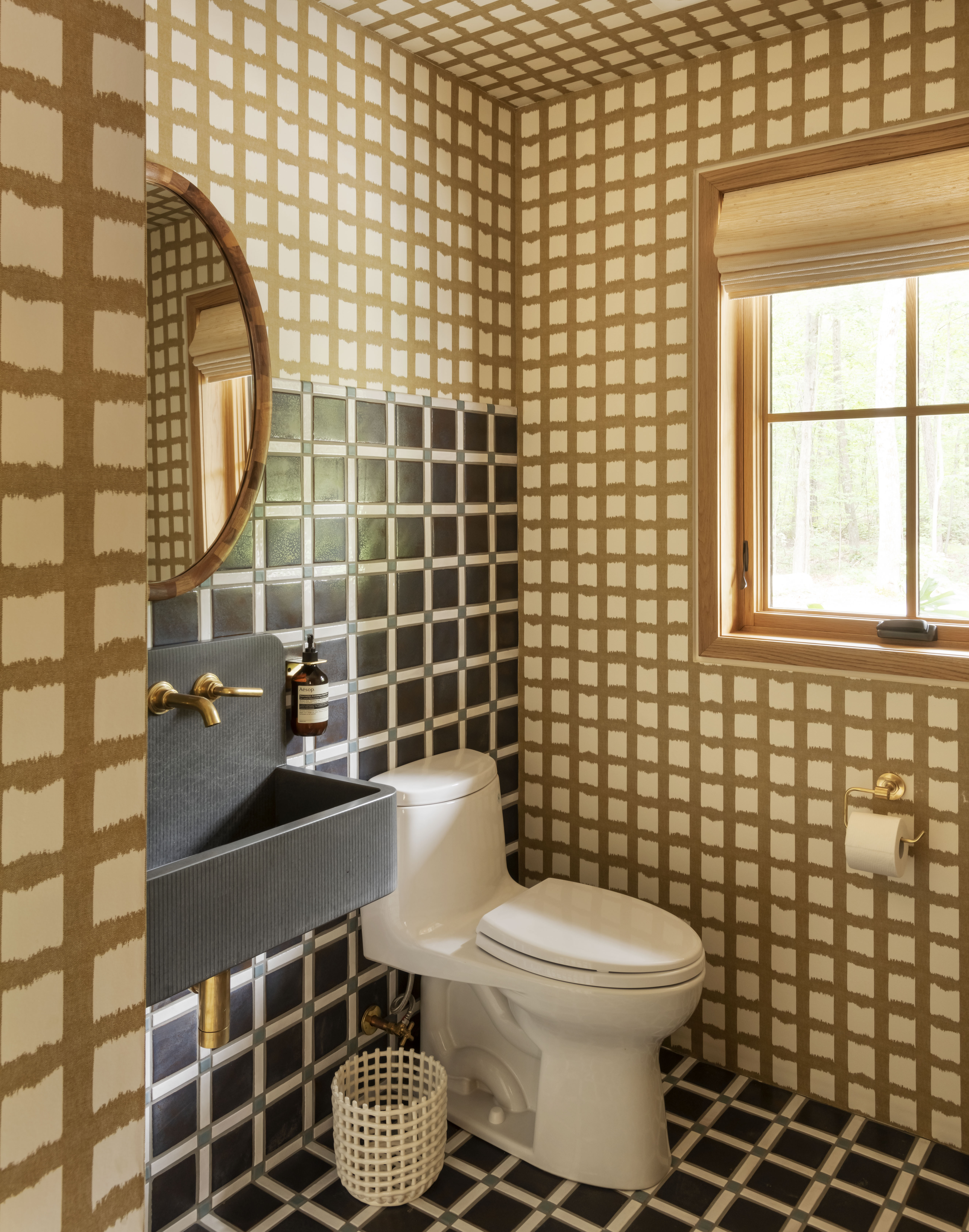 A bathroom with graphic wallpaper, and equally graphic floor tiles