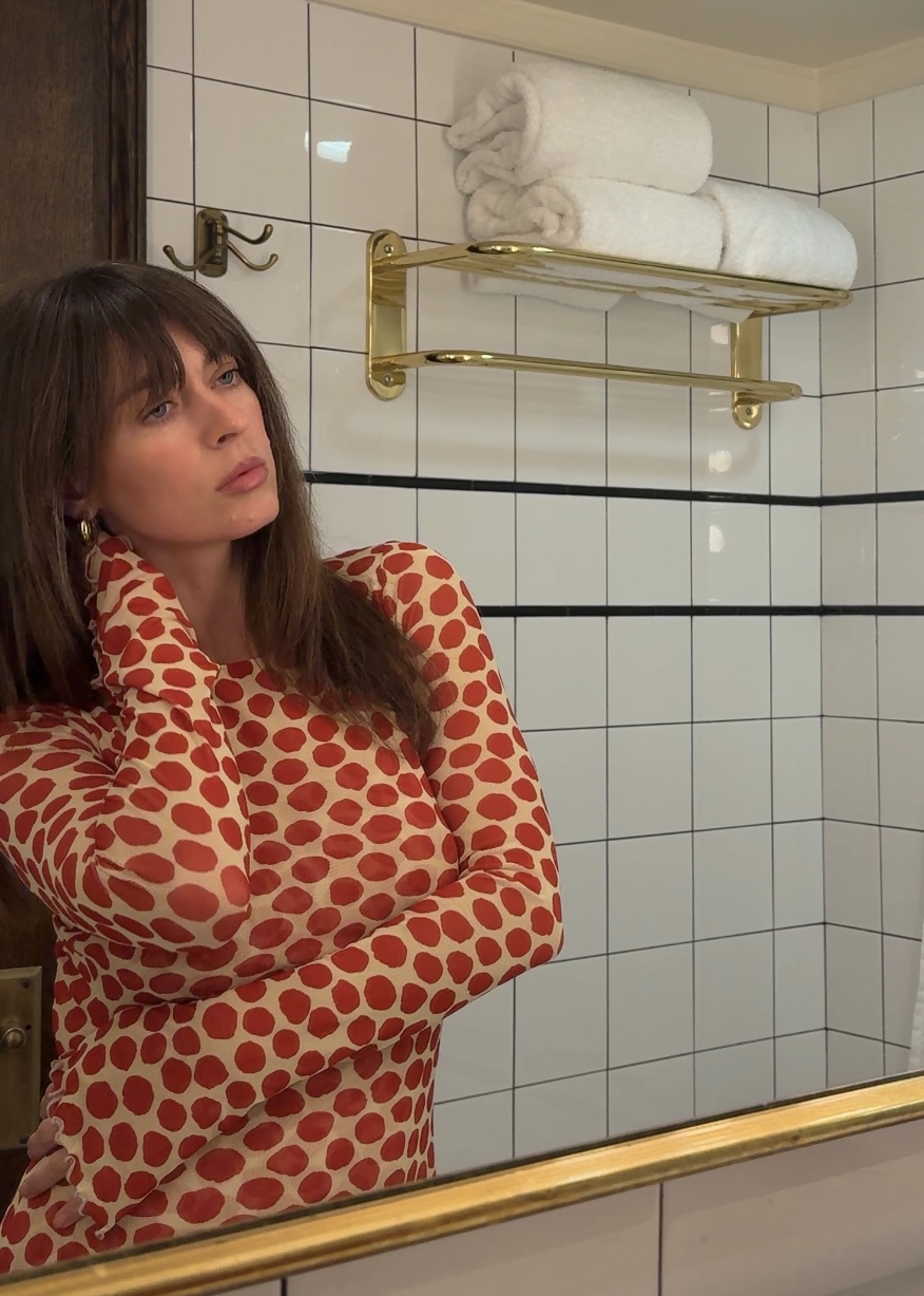 Kathryn Zahorak posing in mirror in red polka dot dress
