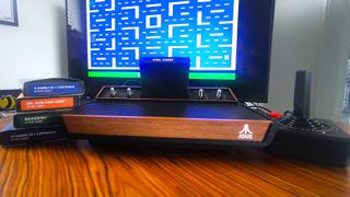 Atari 2600+ console next to cartridges and joystick