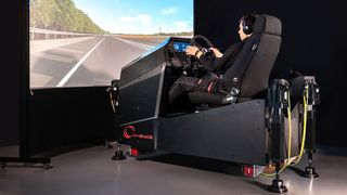 The VI-grade’s COMPACT FSS automotive simulator showing someone virtually driving a car. 