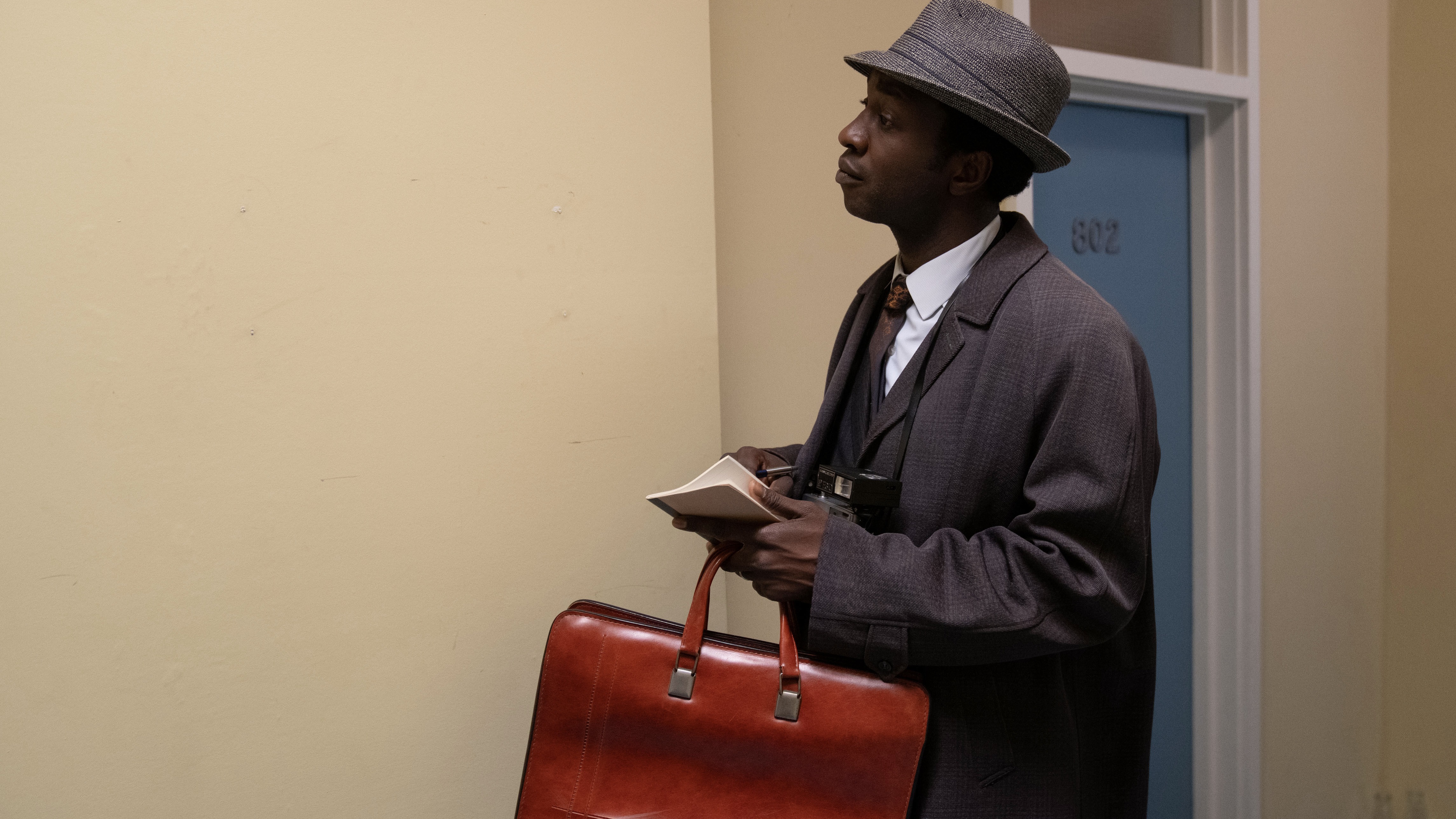 Zephryn Taitte in a suit and hat with a briefcase in Cal the Midwfe.