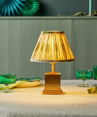 Close up of Walter rechargeable table lamp from Pooky, positioned on dining table with glassware and decorations around