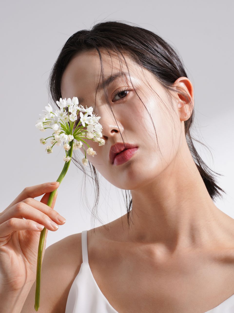 An image showing a woman holding a flower