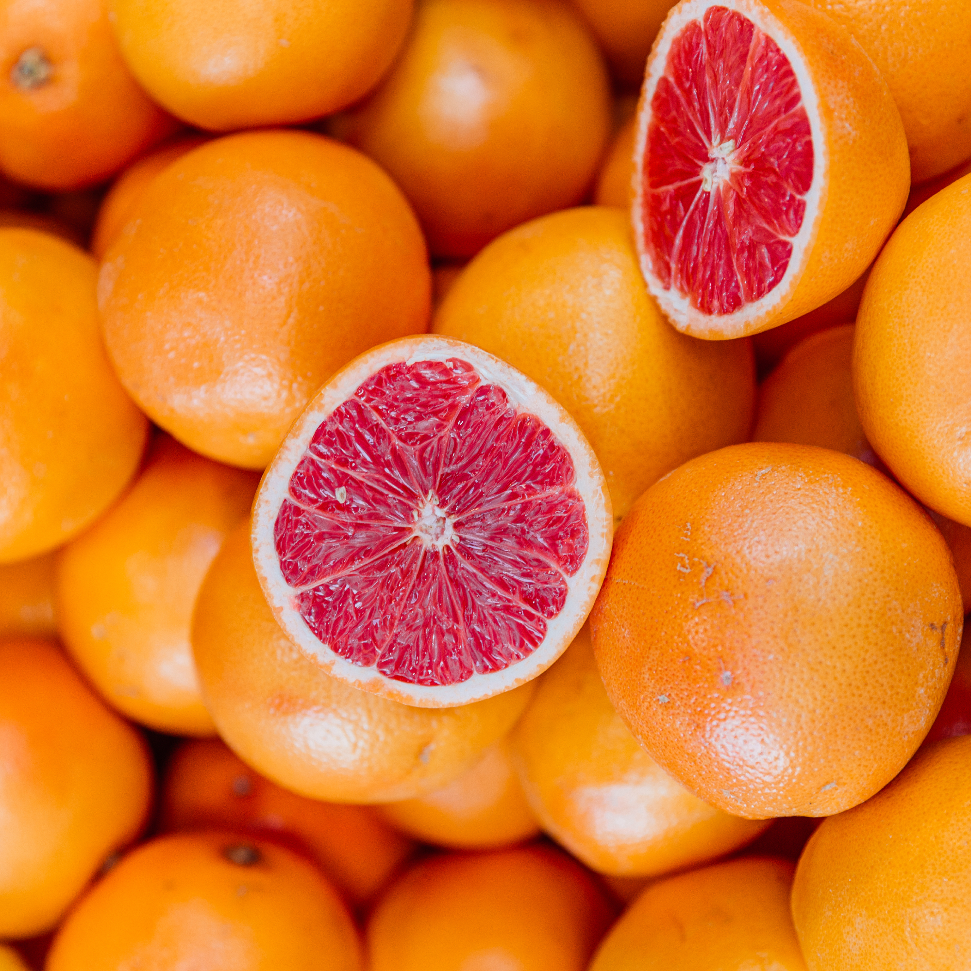 Grapefruit cut in half on top of pile of other grapefruits to create grapefruit slug trap