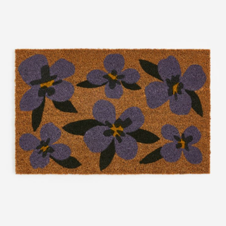 A doormat with purple pansies on it