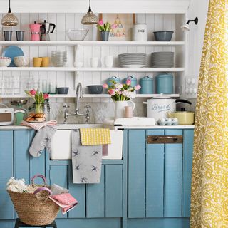 kitchen with white striped wall white shelf on wall and blue cabinets