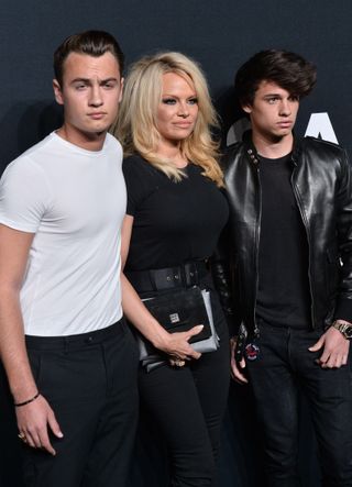 Pamela Anderson and her sons attend the Saint Laurent show at The Hollywood Palladium on February 10, 2016 in Los Angeles, CA