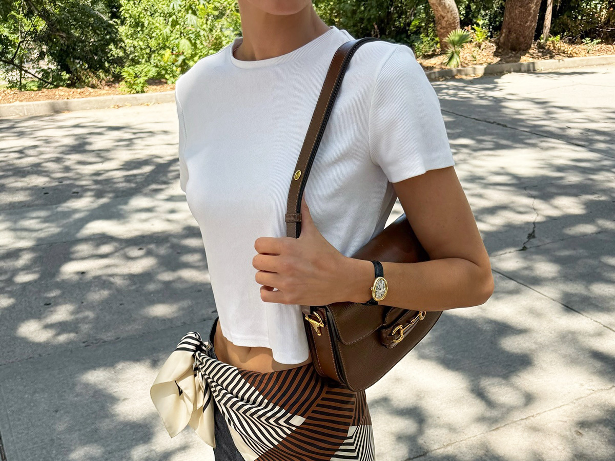 Elsa Hosk wearing a white Helsa T-shirt, Gucci bag, jeans, and scarf belt