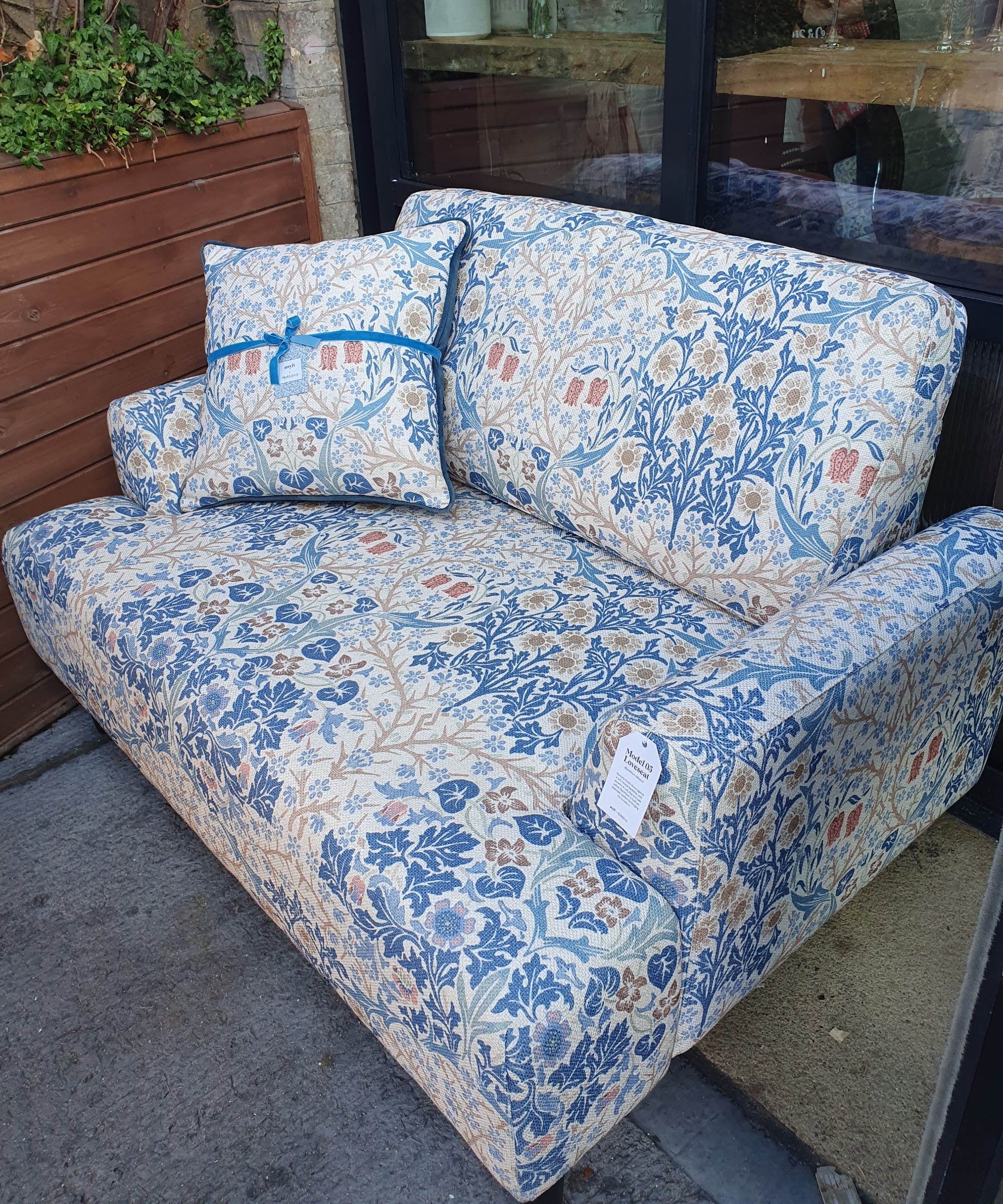 The Swyft x Morris & Co. Model 05 Loveseat in Blackthorn Mineral print with a matching cushion at the press preview of the collection