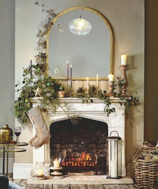 Festive mantelpiece with stocking, mirror and greenery