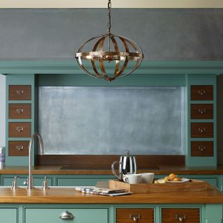 A striking metal pendant acts as ambient lighting, but also acts as task when preparing meals at the kitchen island