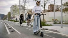 best electric scooter: Person riding a Pure Advance Flex electric scooter on street