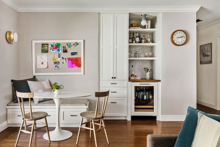 A light grey and white dining area with banquette seating and dining chairs