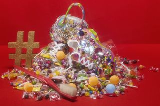 toothbrush and pile of sweets on red background