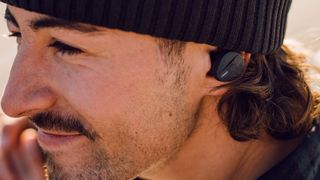 Beyerdynamic Free Byrd lifestyle shot showing man in a hat with beard and wearing earbuds