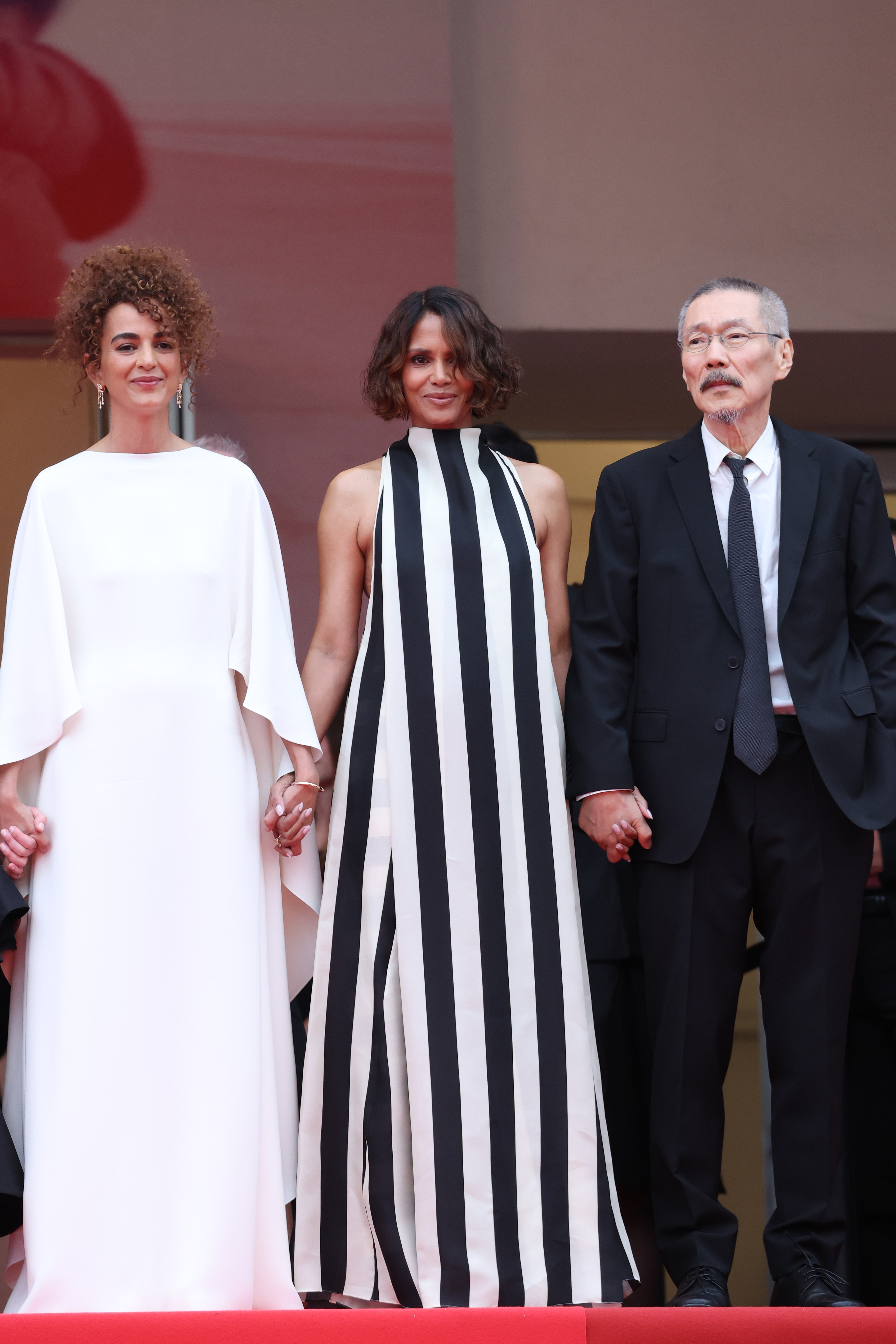 Halle Berry standing on steps at the Cannes Film Festival wearing a striped dress