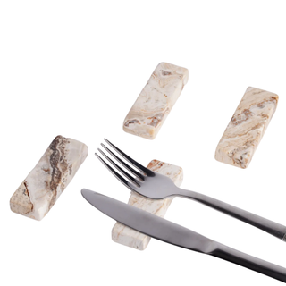 four travertine cutlery rests holding a knife and a fork