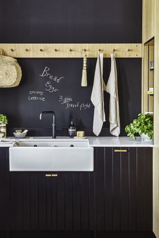 black kitchen sink area with chalkboard paint