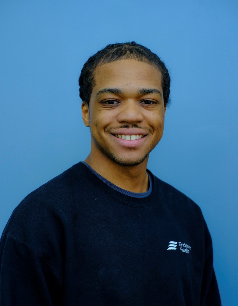 Head and shoulders of man smiling at camera against blue background