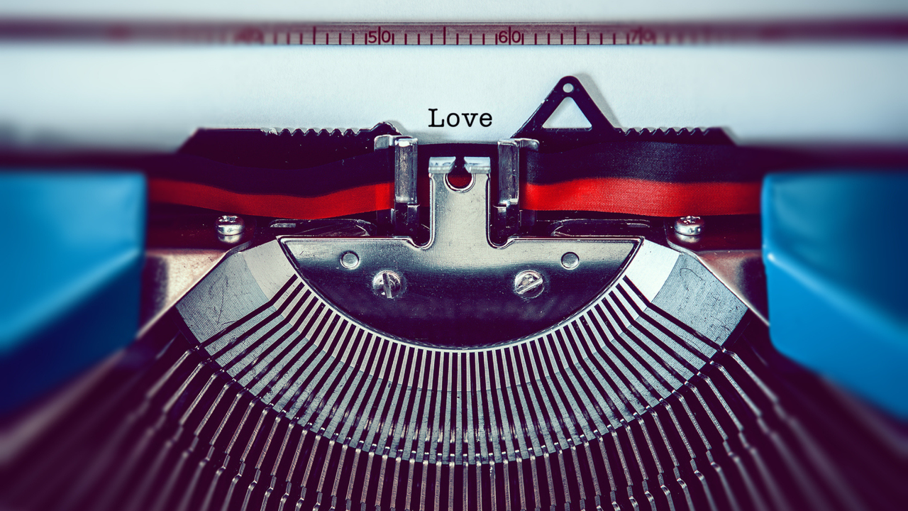 A typewriter types the word &#039;Love&#039; on a piece of paper