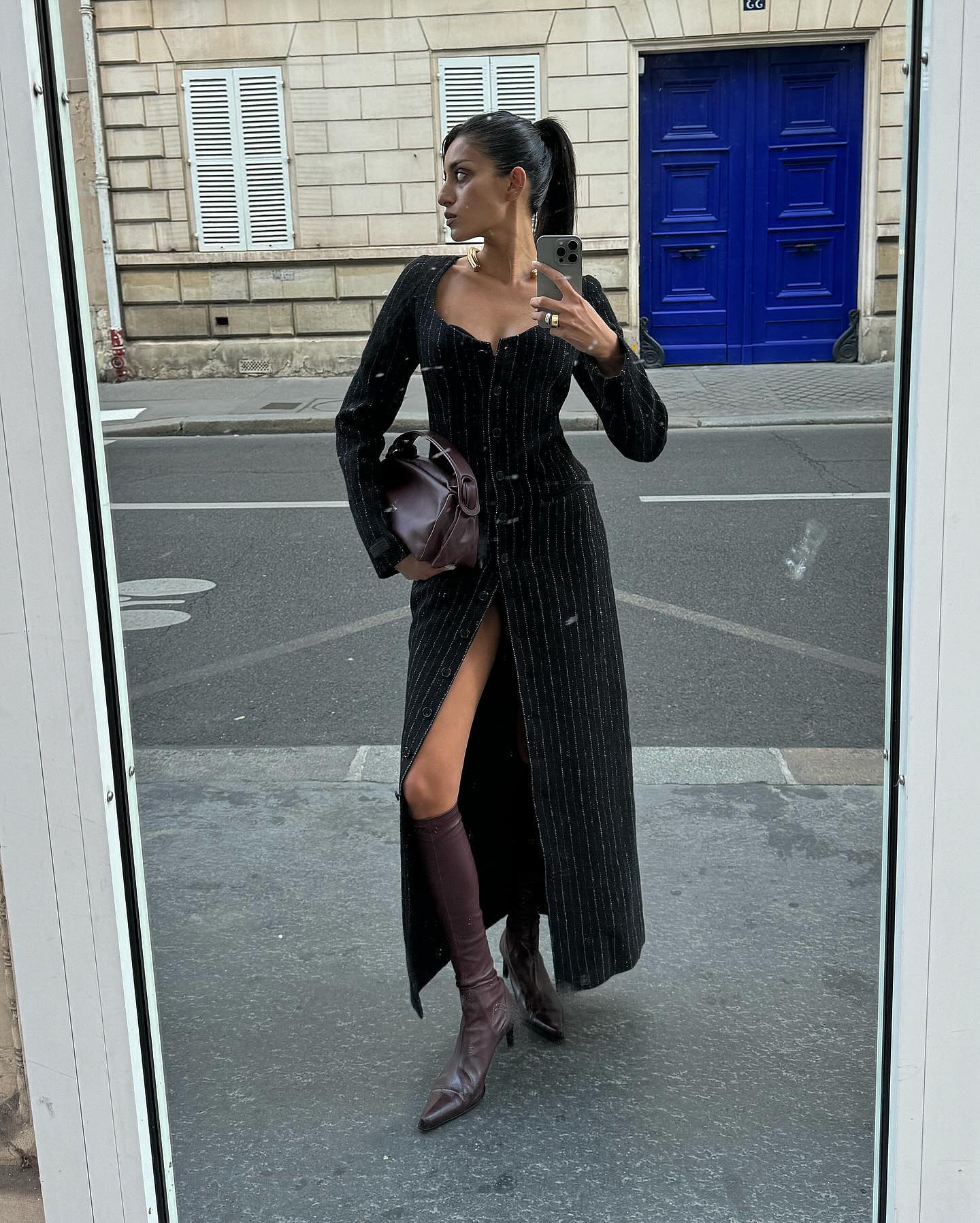 A woman in a long dress on the street.